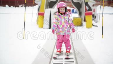 冬季户外运动中的小女孩呆在滑雪传<strong>送</strong>带上。 <strong>孩子</strong>开始滑雪了。 度假村快乐滑雪体验。